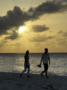 Two people walking on Shoal Bay beach, Angilla at sunset.