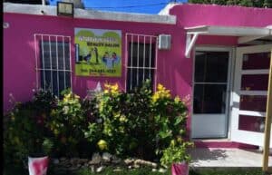 Maranatha Beauty Salon vibrant pink exterior with plants.
